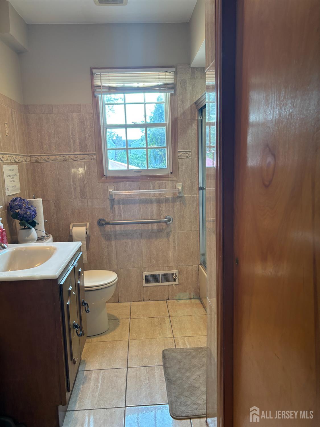 105 Howard Avenue Edison, NJ 08837 - Photo 21 of 39 a bathroom with a toilet a sink and mirror