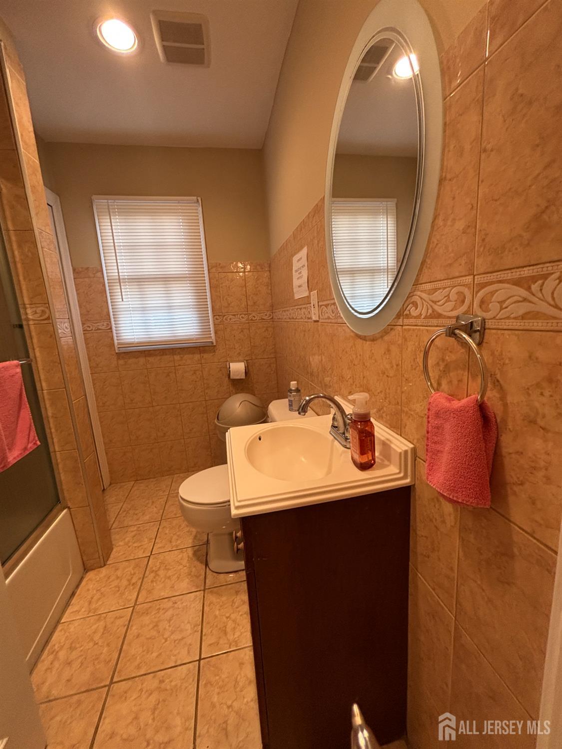 105 Howard Avenue Edison, NJ 08837 - Photo 28 of 39 a bathroom with a sink toilet and a mirror