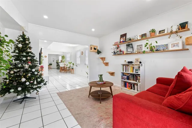 a living room with furniture cabinets and a potted plant