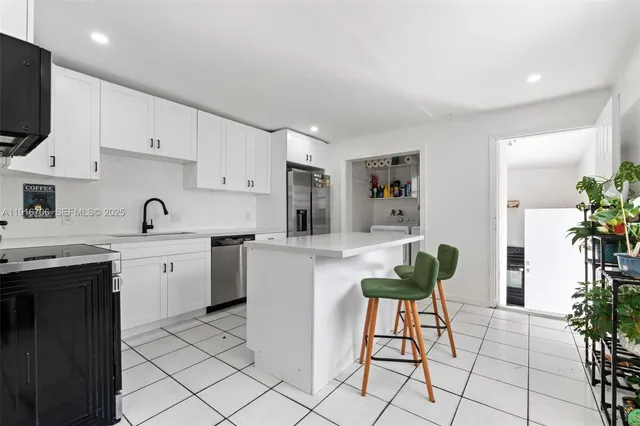 a kitchen with a sink and chairs