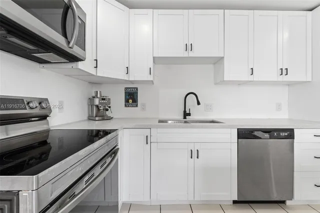 a kitchen with cabinets appliances and a sink
