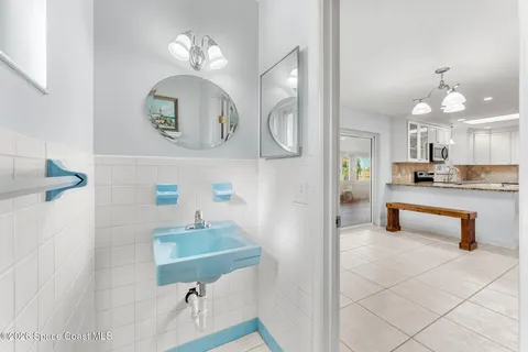 a bathroom with a sink a light fixture and a mirror