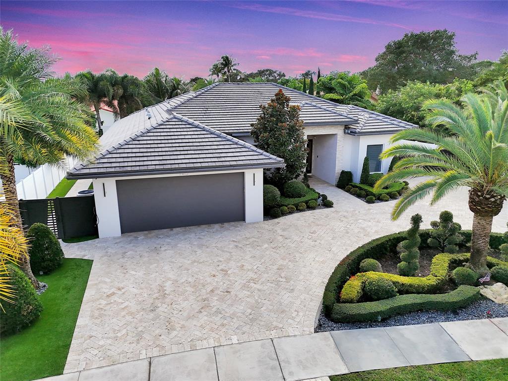 a front view of a house with a garden and plants