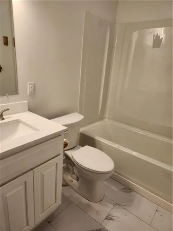 an empty room with wooden floor ceiling fan and windows