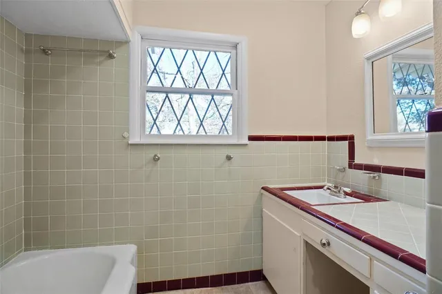 a bathroom with a sink a large window and a bathtub