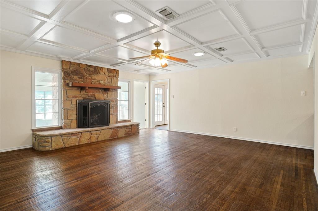 221 West 5th Street Springtown, TX 76082 - Photo 4 of 20 an empty room with wooden floor fireplace and a window
