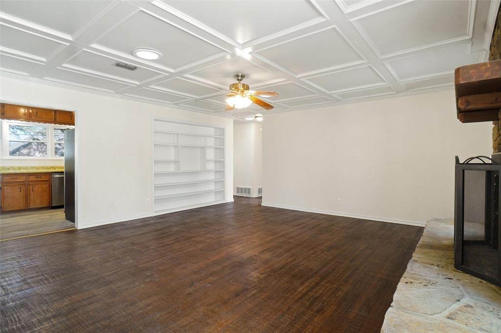 221 West 5th Street Springtown, TX 76082 - Photo 5 of 20 an empty room with wooden floor chandelier fan and windows