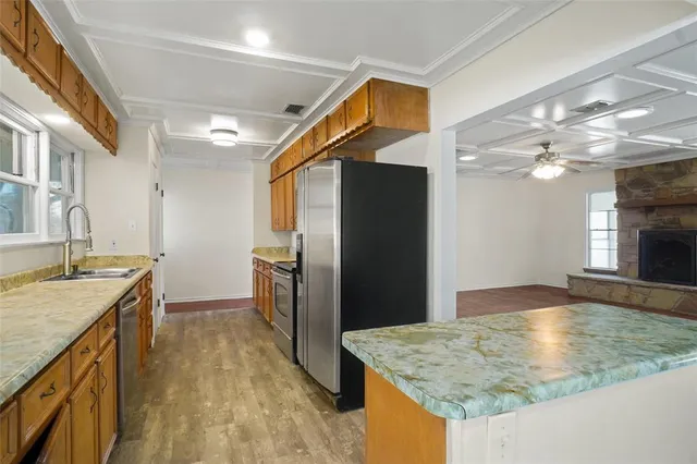 a kitchen with stainless steel appliances granite countertop a sink and a refrigerator