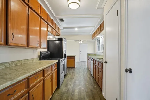 a kitchen with stainless steel appliances granite countertop a sink a stove and a wooden floors