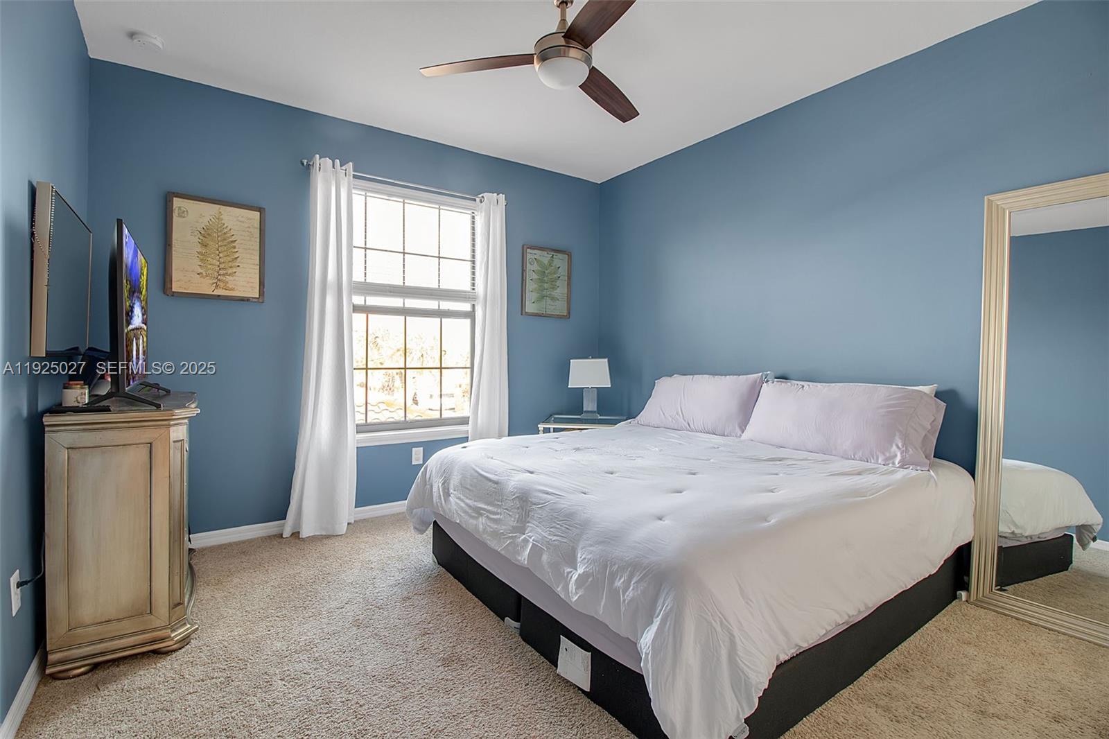 13608 Messina Loop, Unit 201 Bradenton, FL 34211 - Photo 22 of 68 a bedroom with a bed and a flat tv screen on dresser