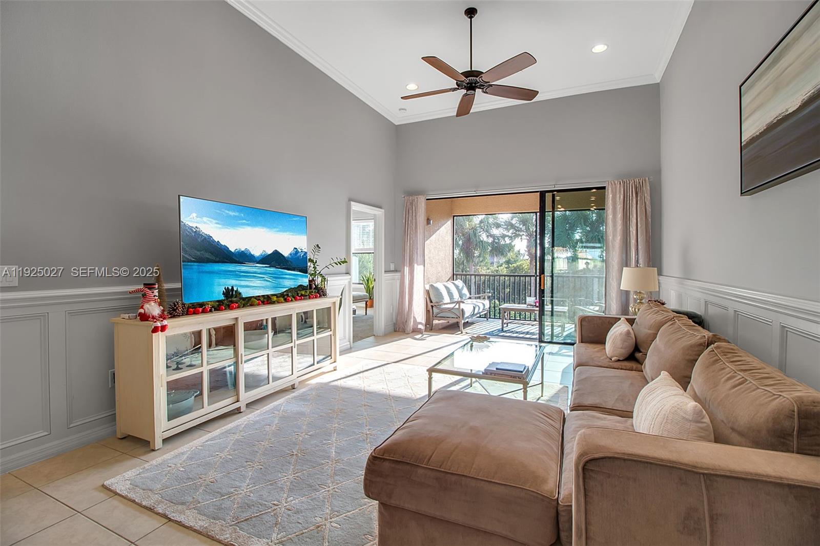 13608 Messina Loop, Unit 201 Bradenton, FL 34211 - Photo 26 of 68 a living room with furniture a flat screen tv and a chandelier