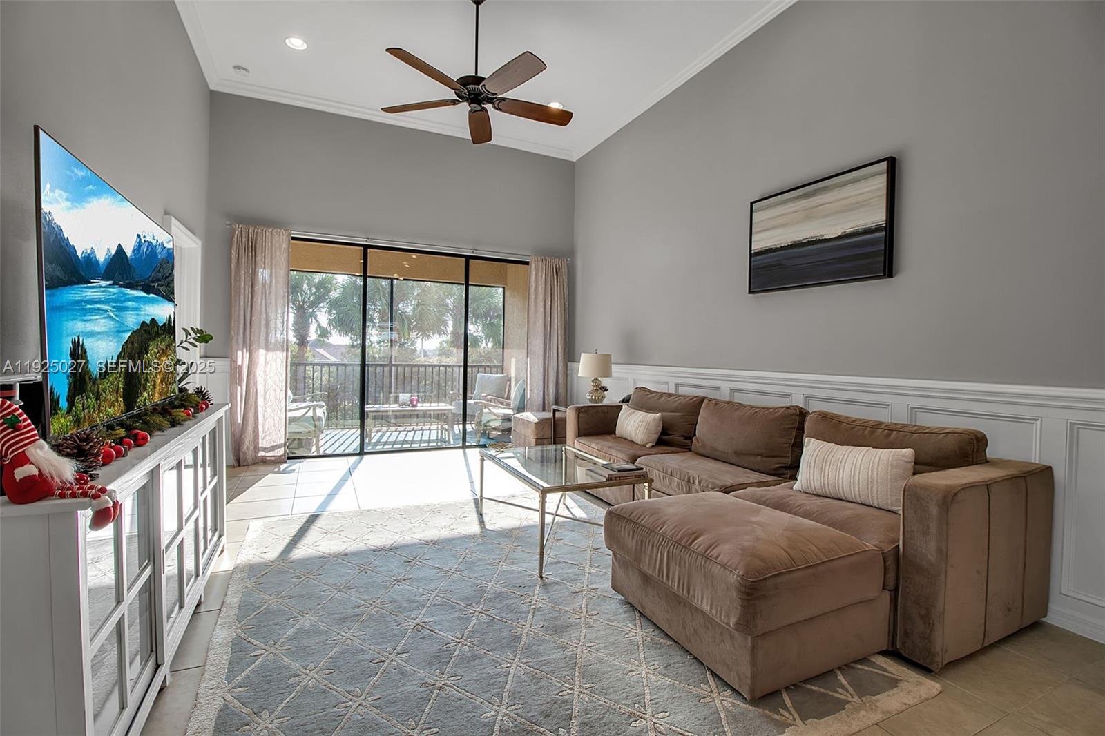 13608 Messina Loop, Unit 201 Bradenton, FL 34211 - Photo 27 of 68 a living room with furniture a flat screen tv and a large window