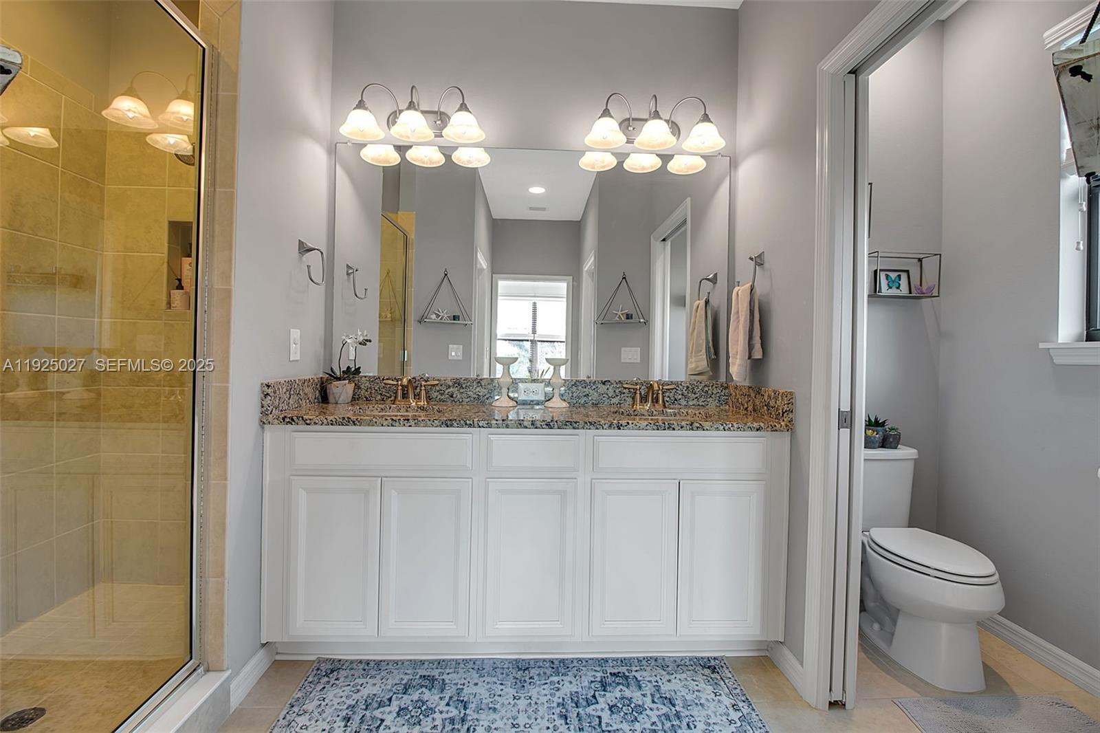 13608 Messina Loop, Unit 201 Bradenton, FL 34211 - Photo 37 of 68 a bathroom with a granite countertop sink a toilet and a mirror