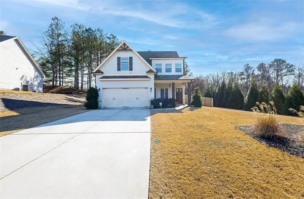 a view of house with yard and trees in the background
