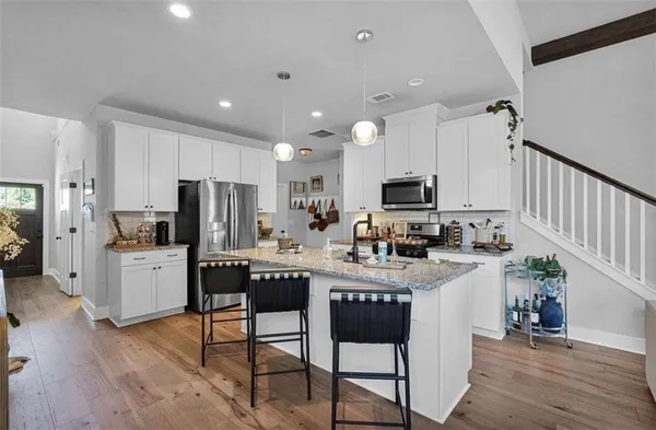 a living room with furniture a flat screen tv and kitchen view