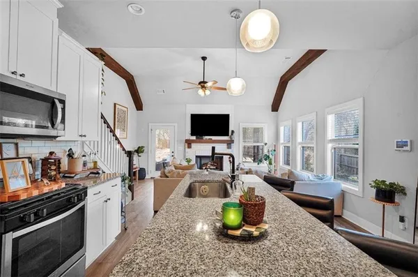 a kitchen with stainless steel appliances granite countertop a sink stove and cabinets