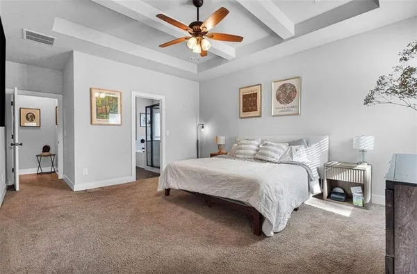 a spacious bedroom with a bed and a chandelier
