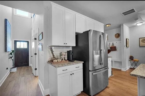 a kitchen with stainless steel appliances a dining table chairs microwave and refrigerator