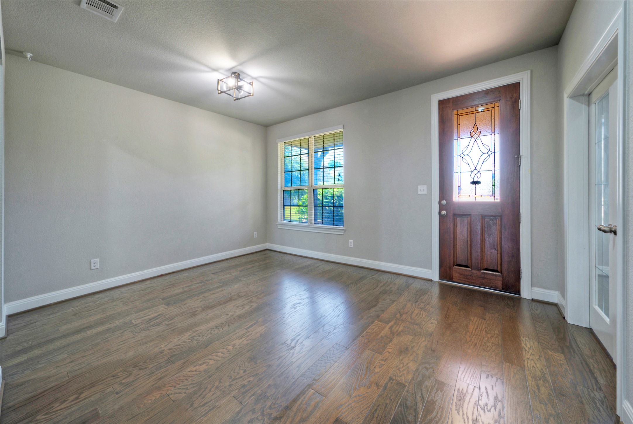 2260 Hat Bender Loop Round Rock, TX 78664 - Photo 5 of 40 Hardwood floors grace the welcoming entry, complemented by a charming stained glass front door.