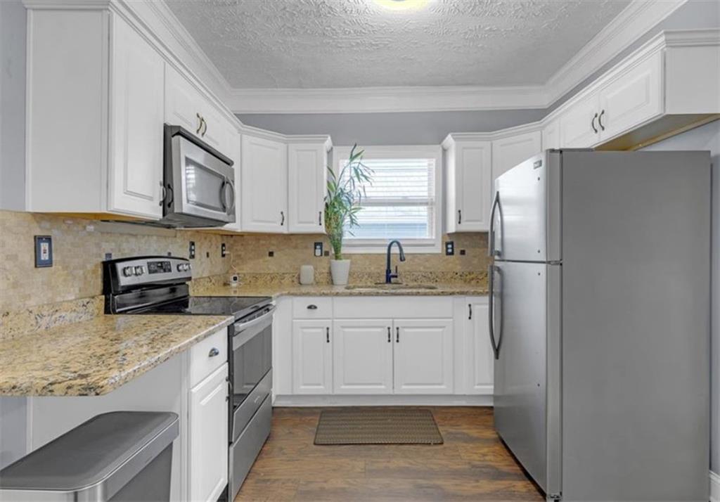 1146 Sims Street Southwest Atlanta, GA 30310 - Photo 12 of 20 a kitchen with stainless steel appliances granite countertop a refrigerator sink and stove