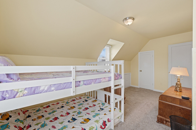 7576 South Jefferson Street Midvale, UT 84047 - Photo 24 of 53 Carpeted room with a vaulted ceiling, a built-in window seat, two panel doors, and a flush-mount ceiling light fixture
