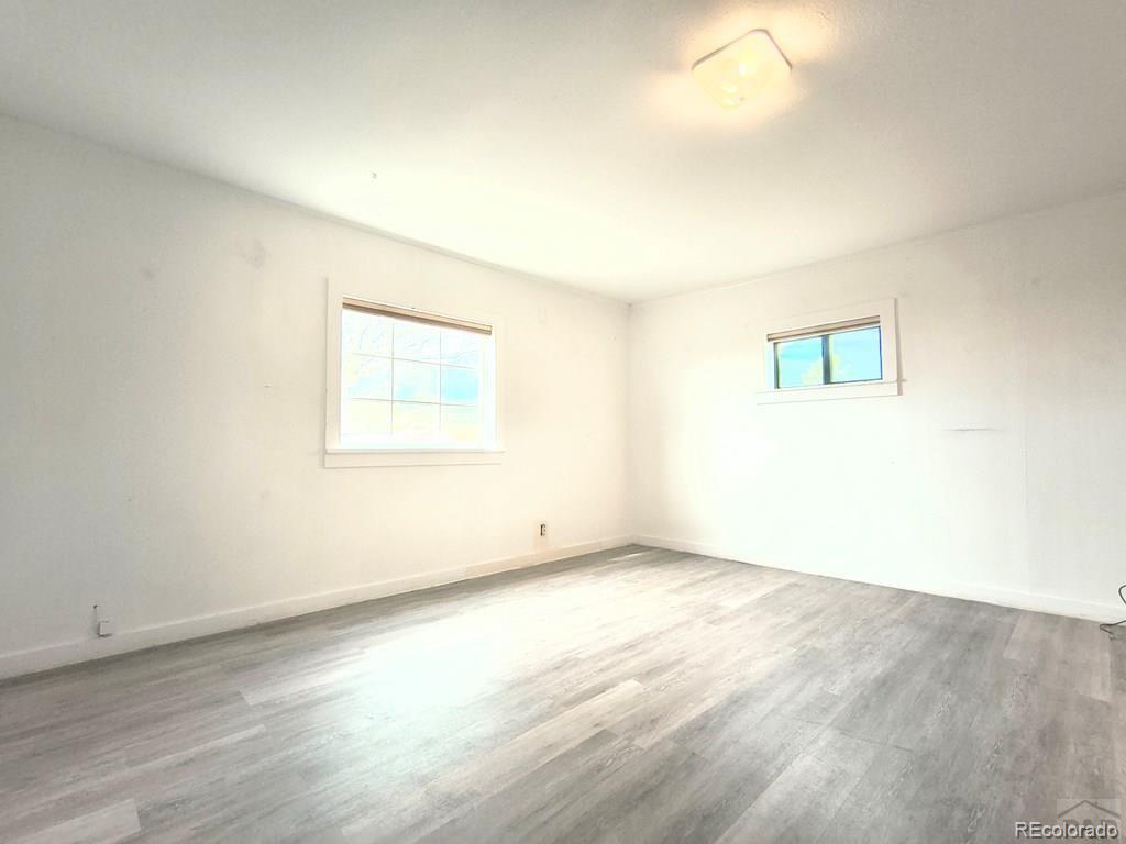 8180 Old San Isabel Road Rye, CO 81069 - Photo 19 of 35 an empty room with wooden floor and windows
