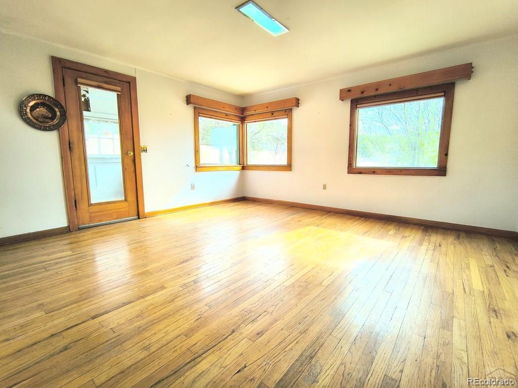 8180 Old San Isabel Road Rye, CO 81069 - Photo 8 of 35 a view of an empty room with wooden floor and a window