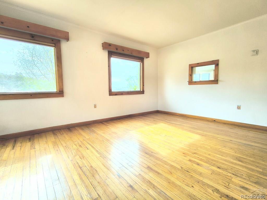 8180 Old San Isabel Road Rye, CO 81069 - Photo 9 of 35 a view of an empty room with wooden floor and a window