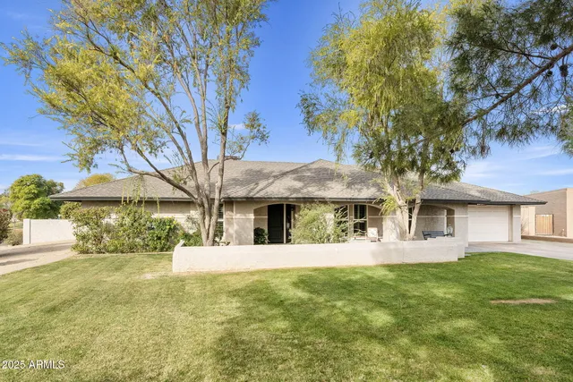a front view of a house with a yard and potted plants