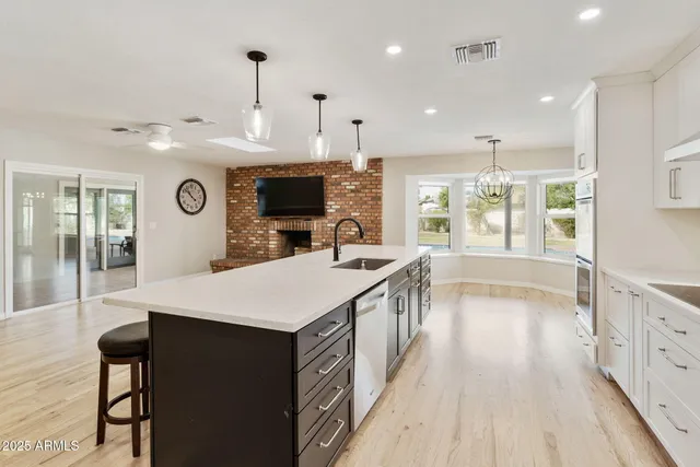 a kitchen with stainless steel appliances kitchen island granite countertop a refrigerator and a stove top oven