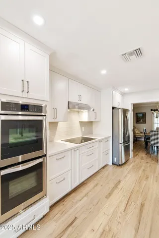 a dining room with furniture a chandelier and wooden floor