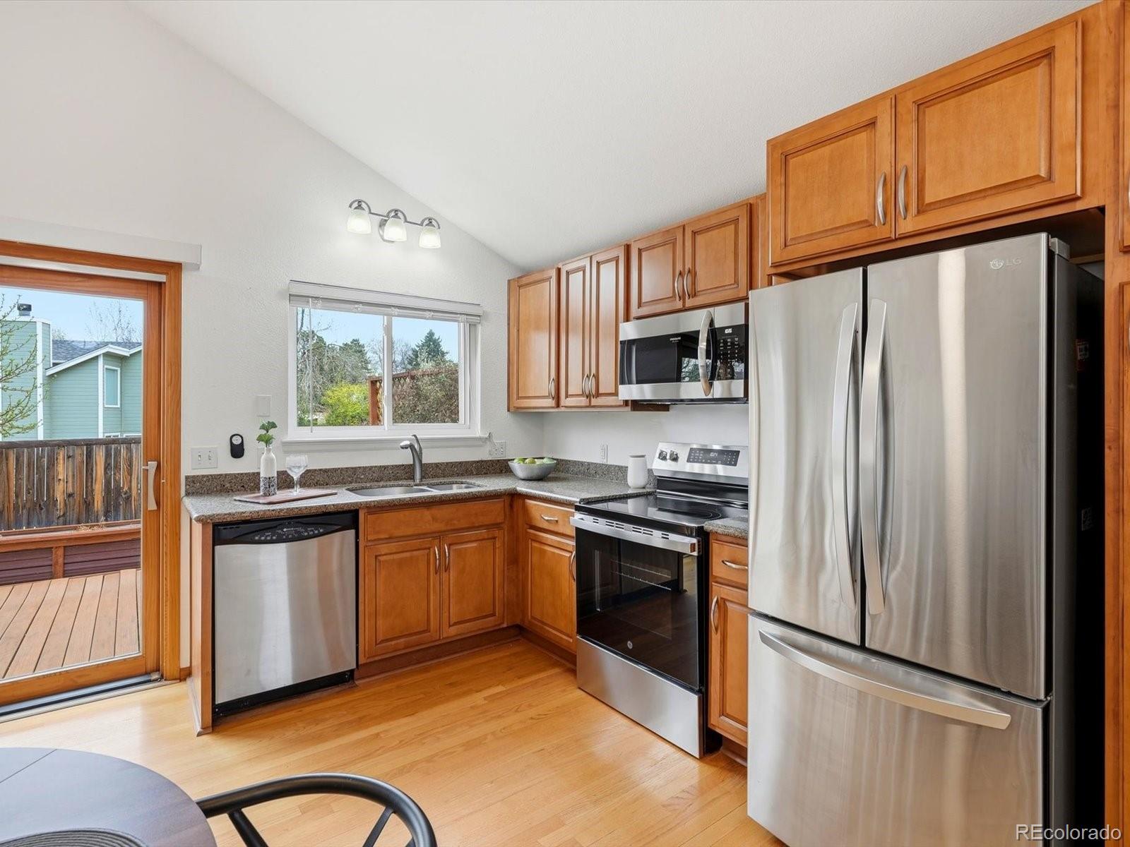 765 Stowe Street Highlands Ranch, CO 80126 - Photo 12 of 43 a kitchen with stainless steel appliances granite countertop a refrigerator stove top oven and sink
