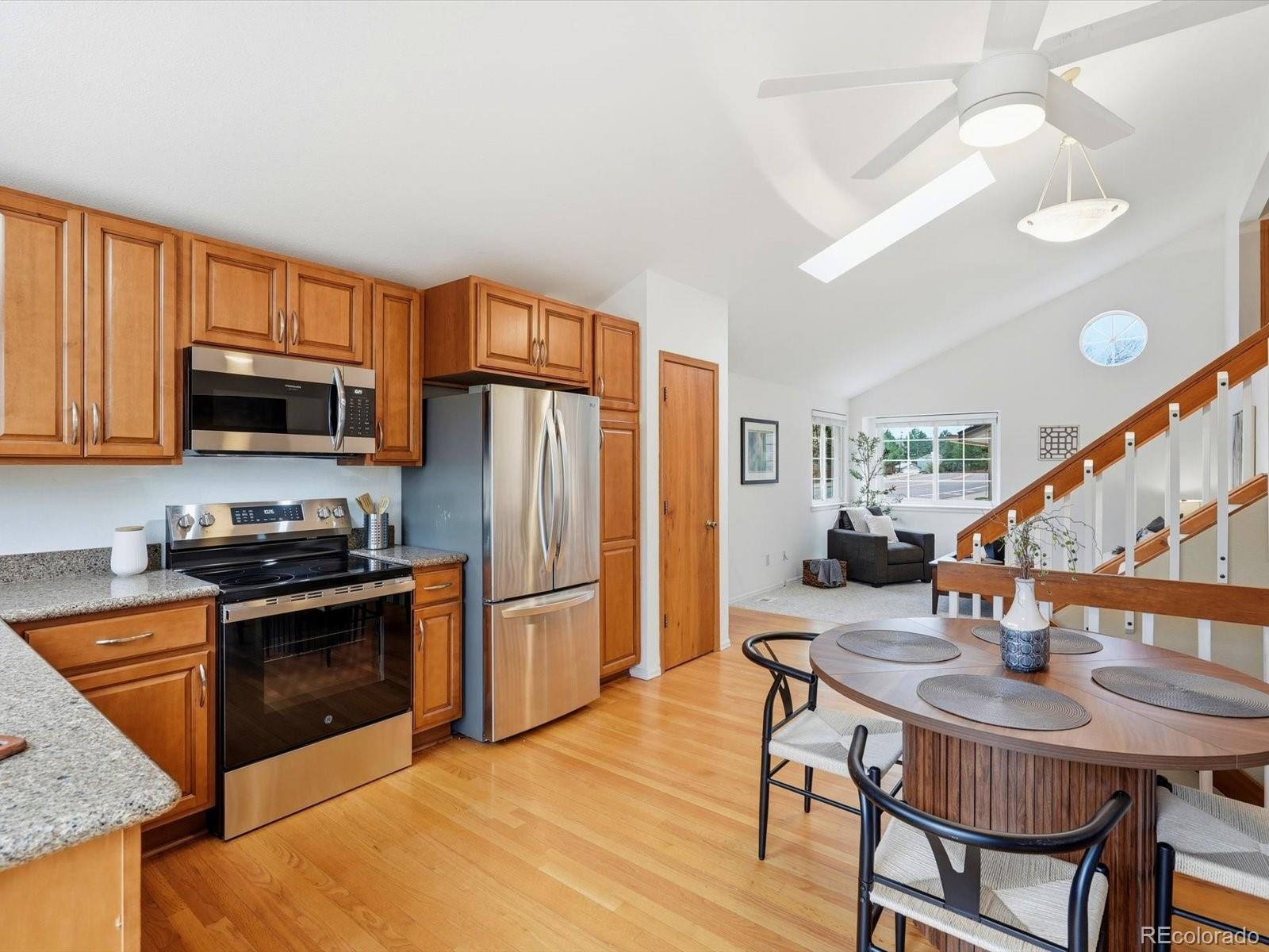 765 Stowe Street Highlands Ranch, CO 80126 - Photo 15 of 43 a kitchen with stainless steel appliances granite countertop a sink a microwave refrigerator and chairs