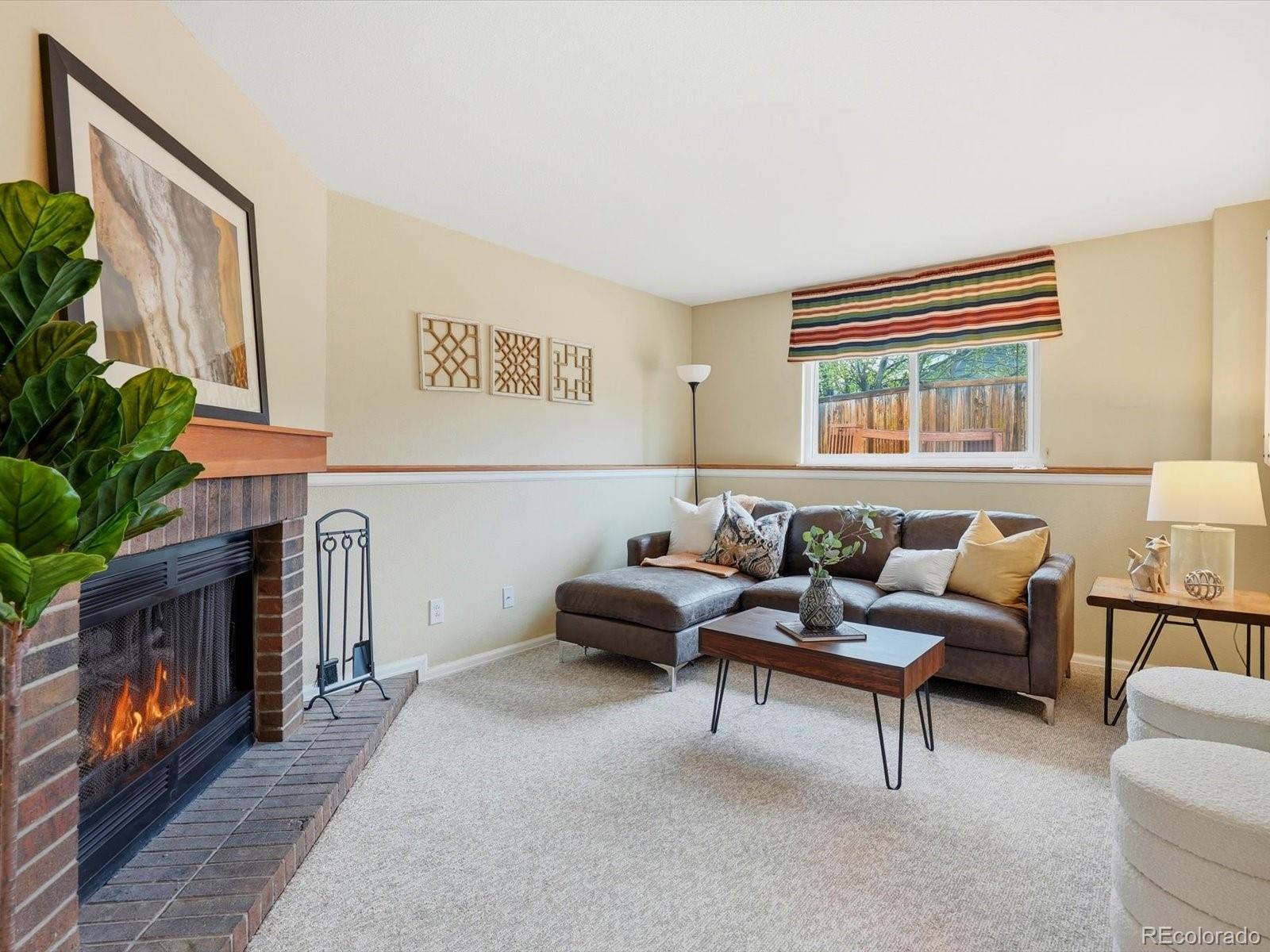 765 Stowe Street Highlands Ranch, CO 80126 - Photo 18 of 43 a living room with furniture and a fireplace