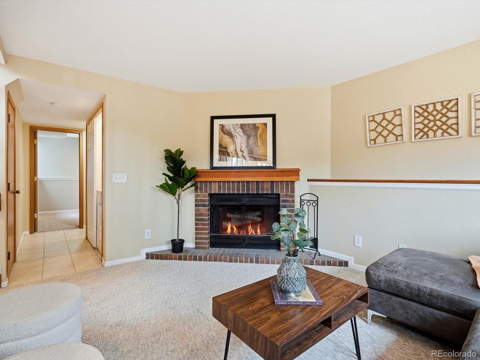 765 Stowe Street Highlands Ranch, CO 80126 - Photo 19 of 43 a living room with furniture and a fireplace