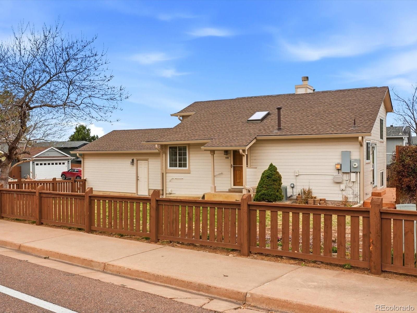 765 Stowe Street Highlands Ranch, CO 80126 - Photo 2 of 43 a front view of house with wooden fence