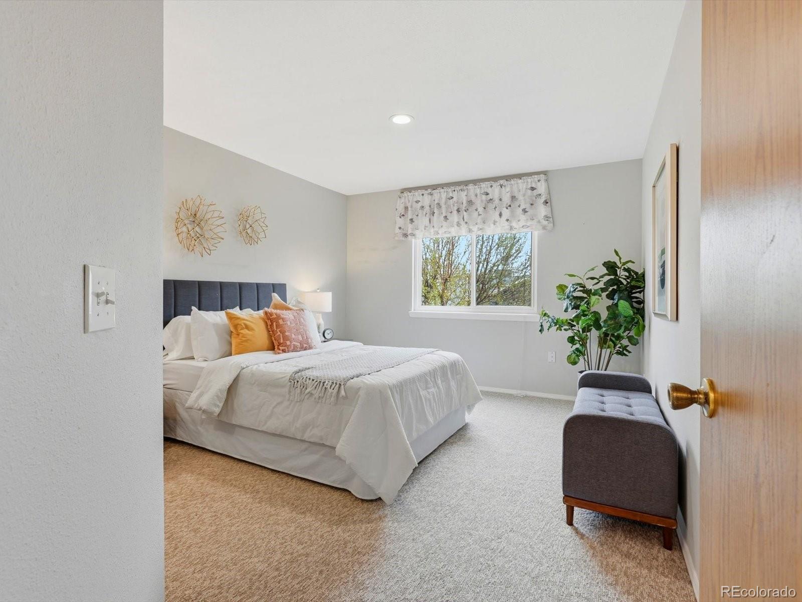 765 Stowe Street Highlands Ranch, CO 80126 - Photo 24 of 43 a bedroom with a bed lamp and window