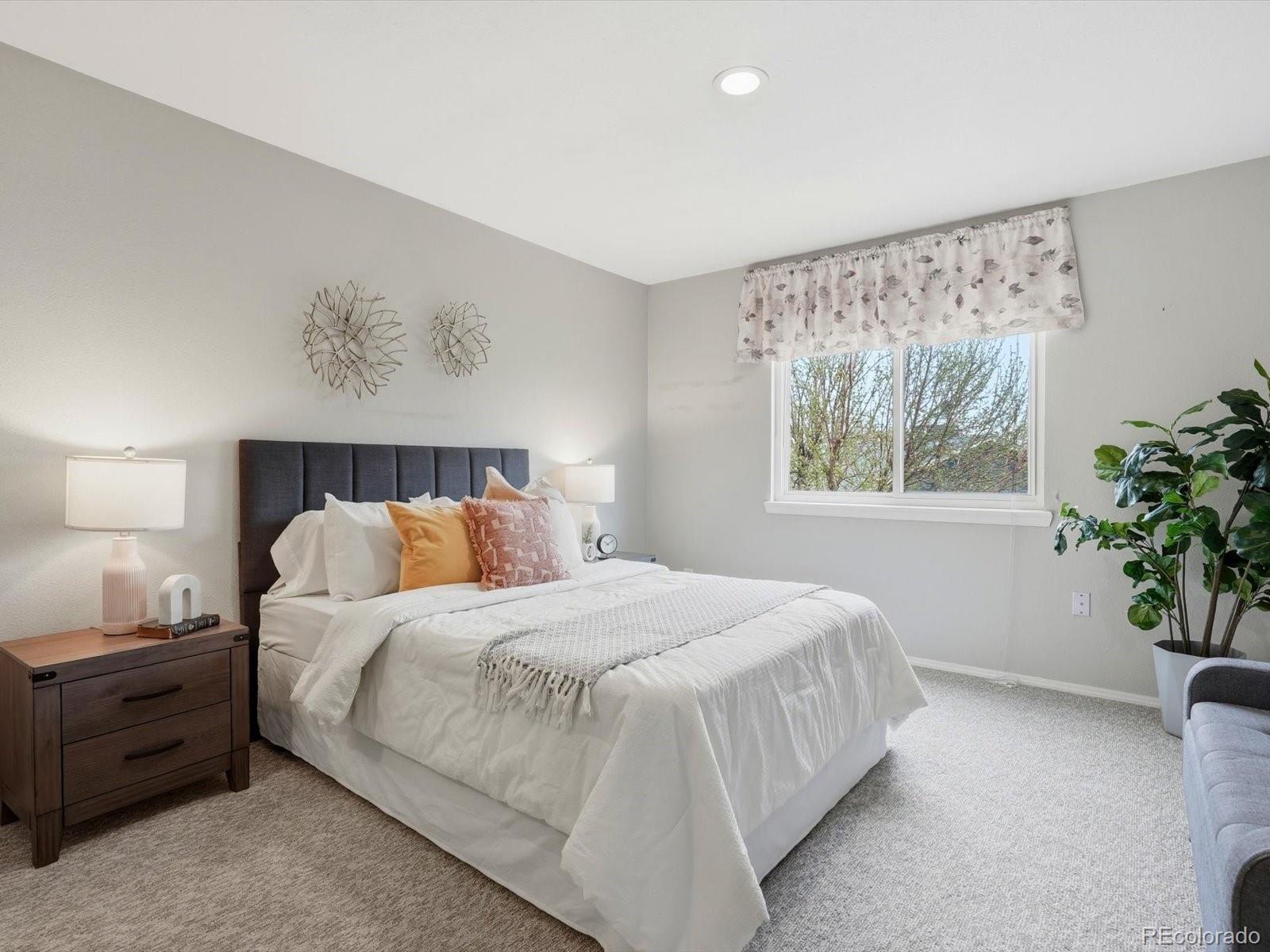 765 Stowe Street Highlands Ranch, CO 80126 - Photo 25 of 43 a bedroom with a large bed and a potted plant