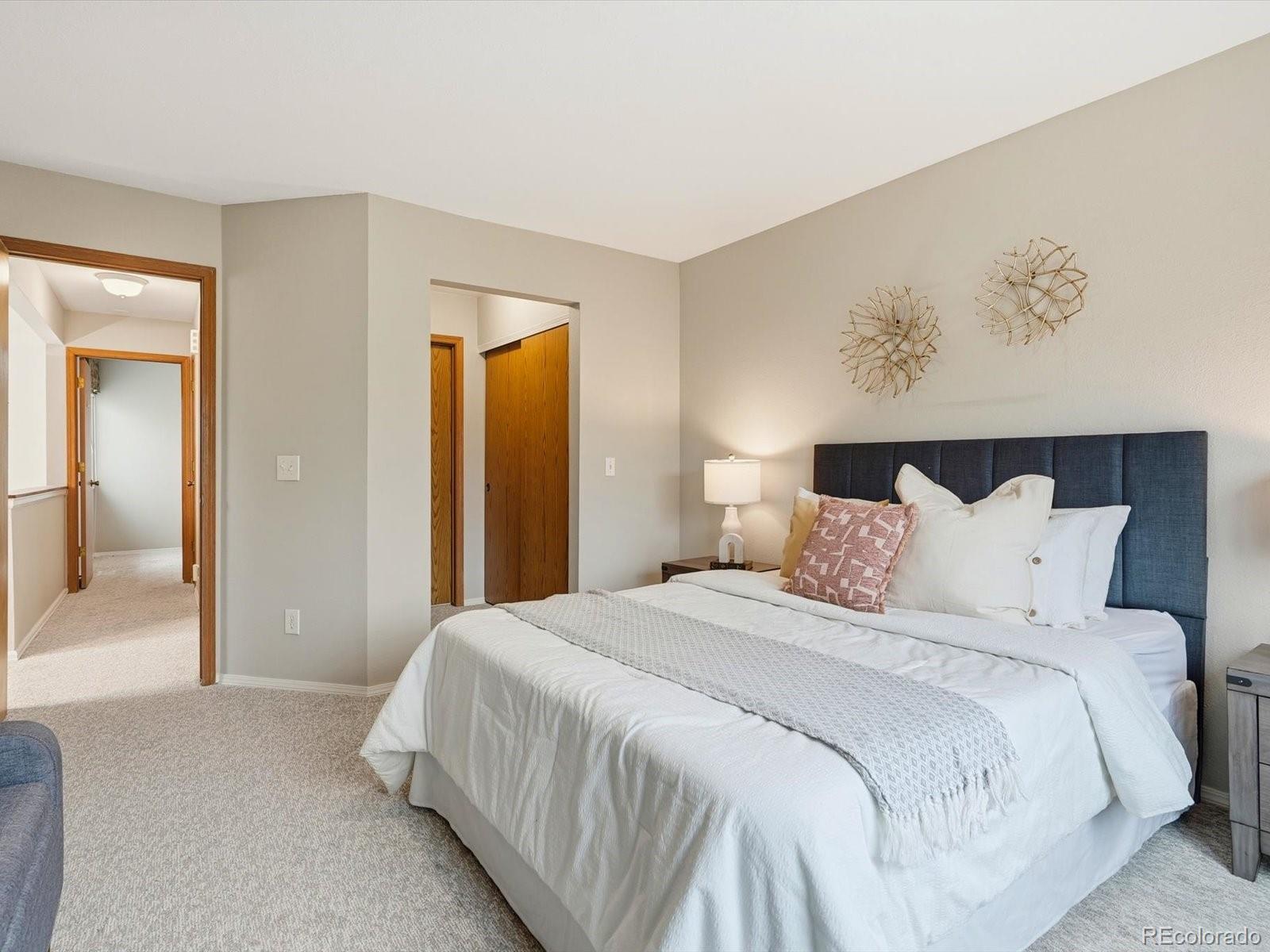 765 Stowe Street Highlands Ranch, CO 80126 - Photo 26 of 43 a bedroom with a large bed and a painting on the wall