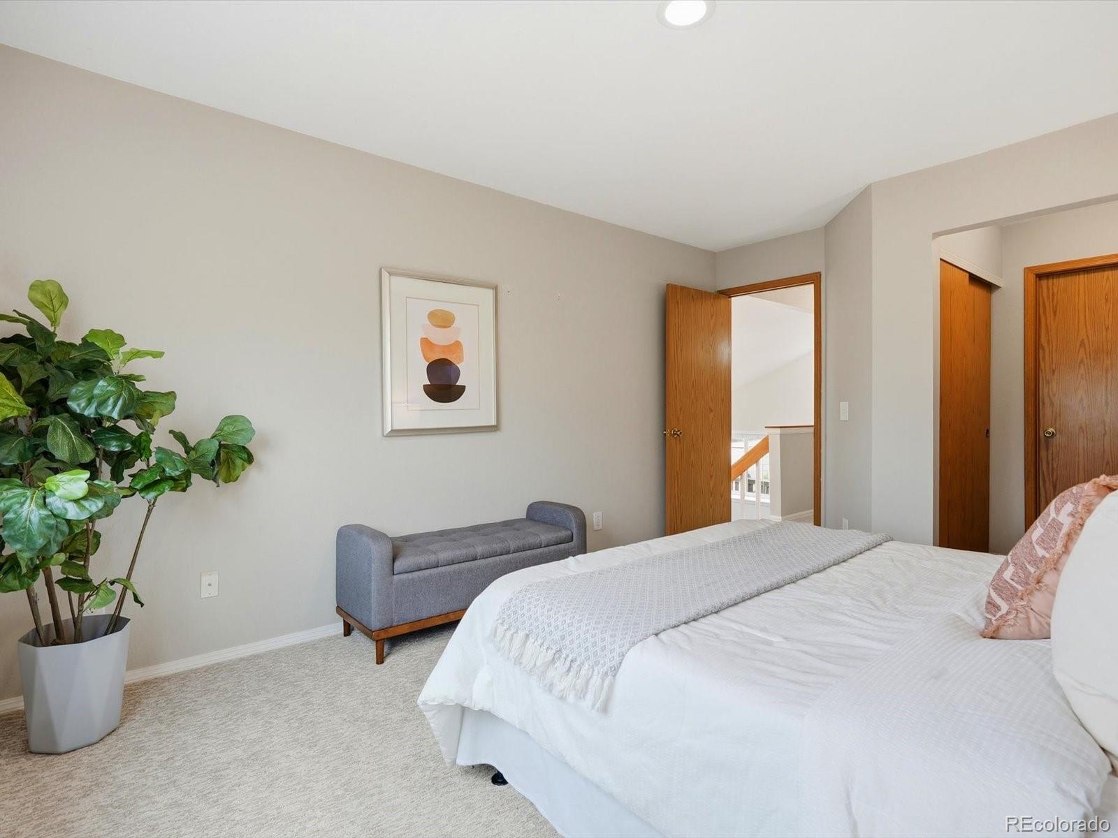 765 Stowe Street Highlands Ranch, CO 80126 - Photo 27 of 43 a bedroom with bed and a potted plant