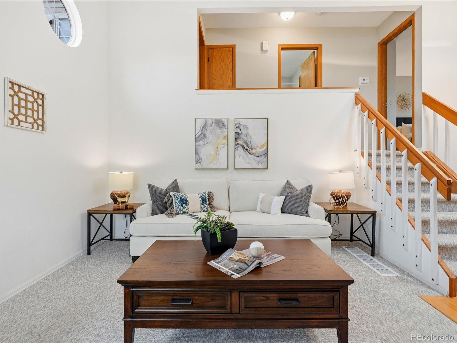 765 Stowe Street Highlands Ranch, CO 80126 - Photo 8 of 43 a living room with furniture and paintings on the wall