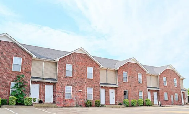 a front view of a brick house with a yard