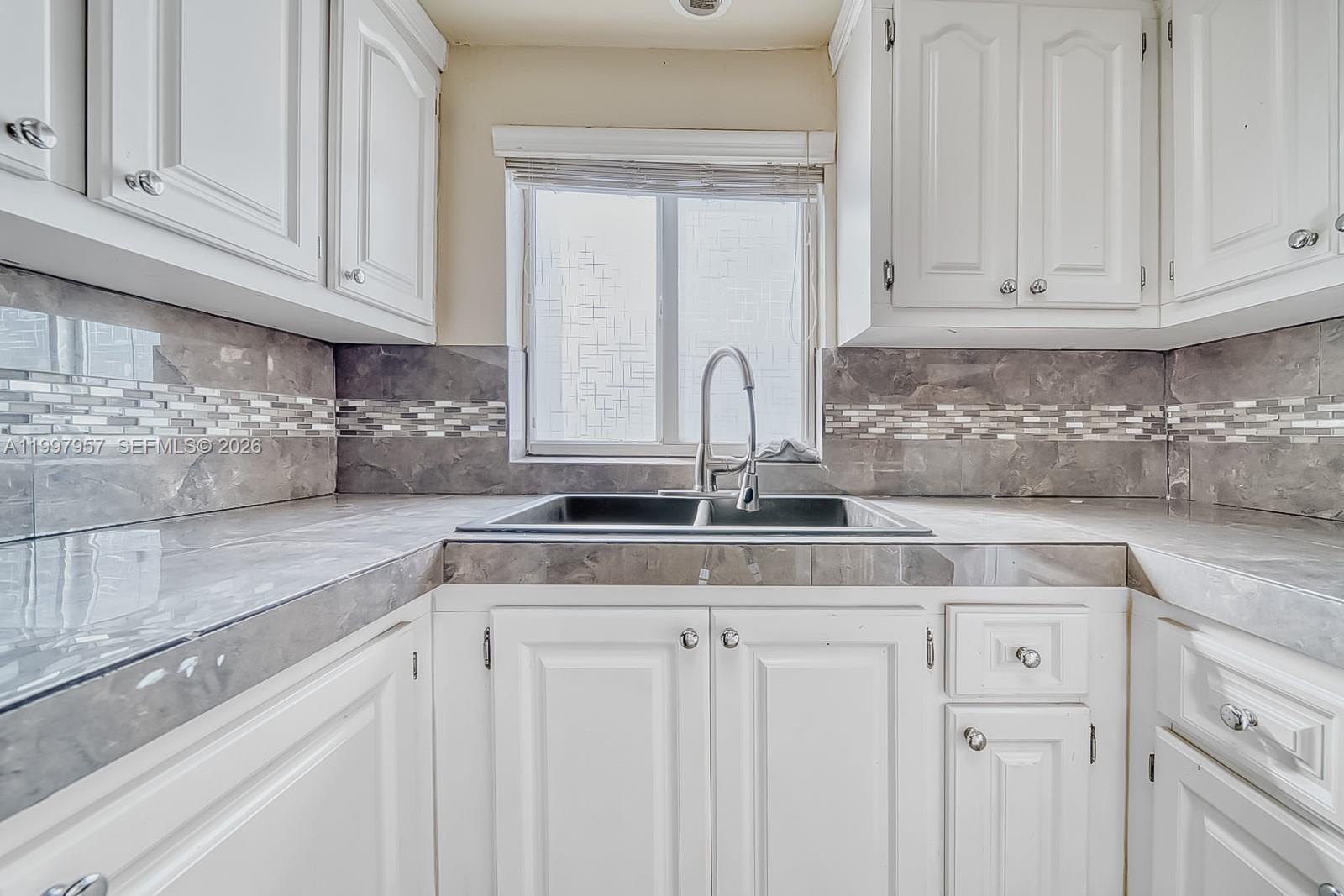 2171 Southwest 21st Street Miami, FL 33145 - Photo 17 of 31 a kitchen with white cabinets and a sink