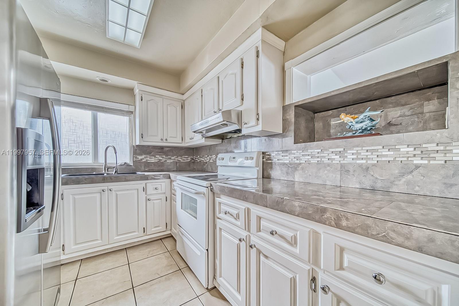 2171 Southwest 21st Street Miami, FL 33145 - Photo 3 of 31 a kitchen with granite countertop white cabinets and white appliances