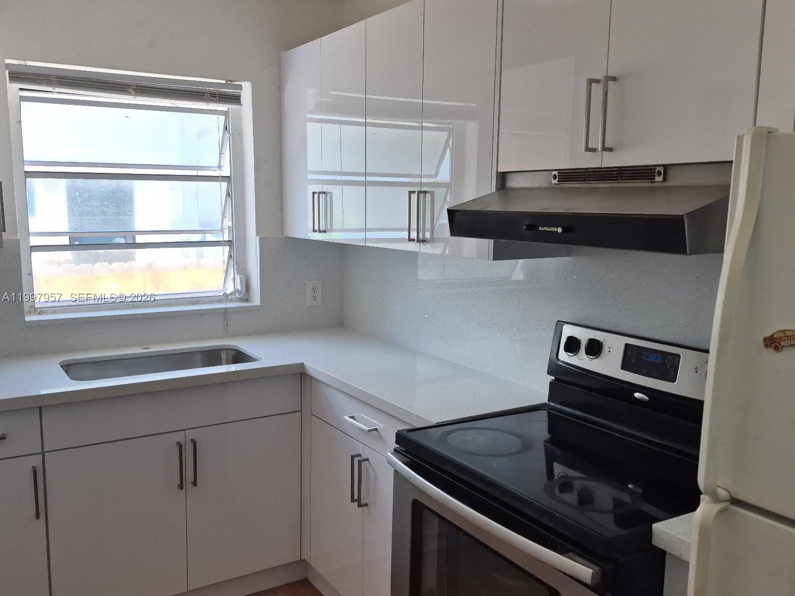 2171 Southwest 21st Street Miami, FL 33145 - Photo 4 of 31 a kitchen with a stove and a sink