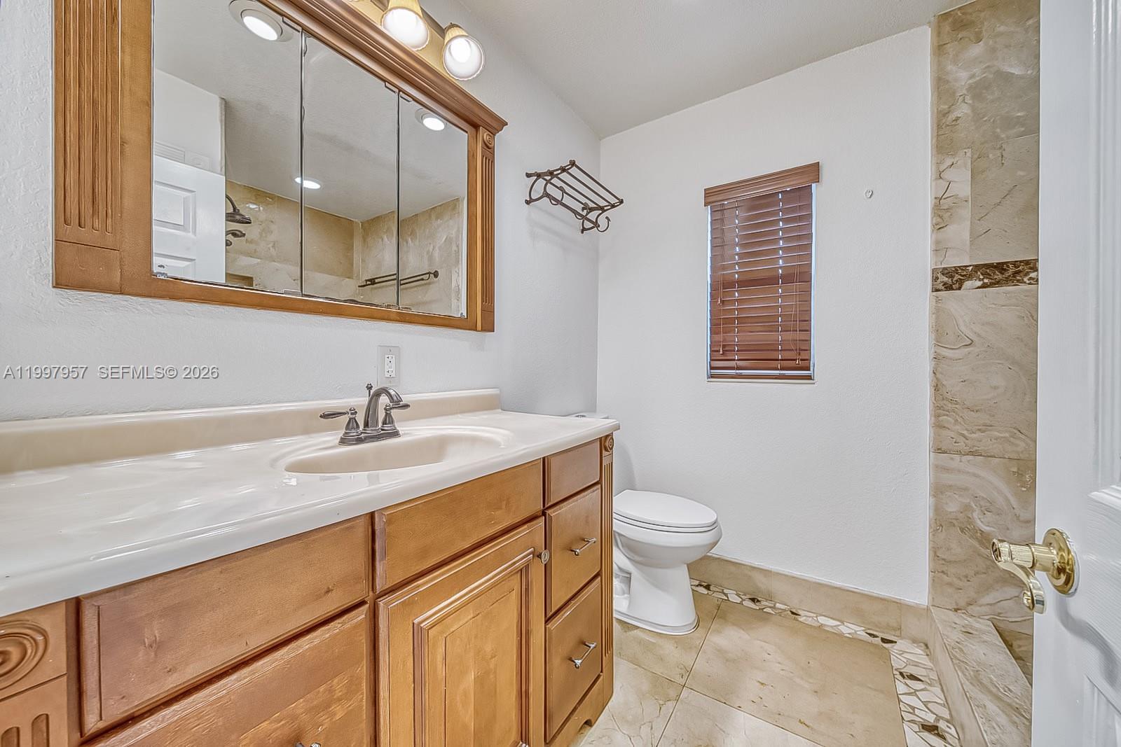 2171 Southwest 21st Street Miami, FL 33145 - Photo 7 of 31 a bathroom with a granite countertop sink toilet and mirror