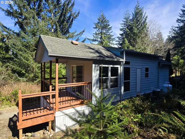 a view of a house with wooden deck and furniture