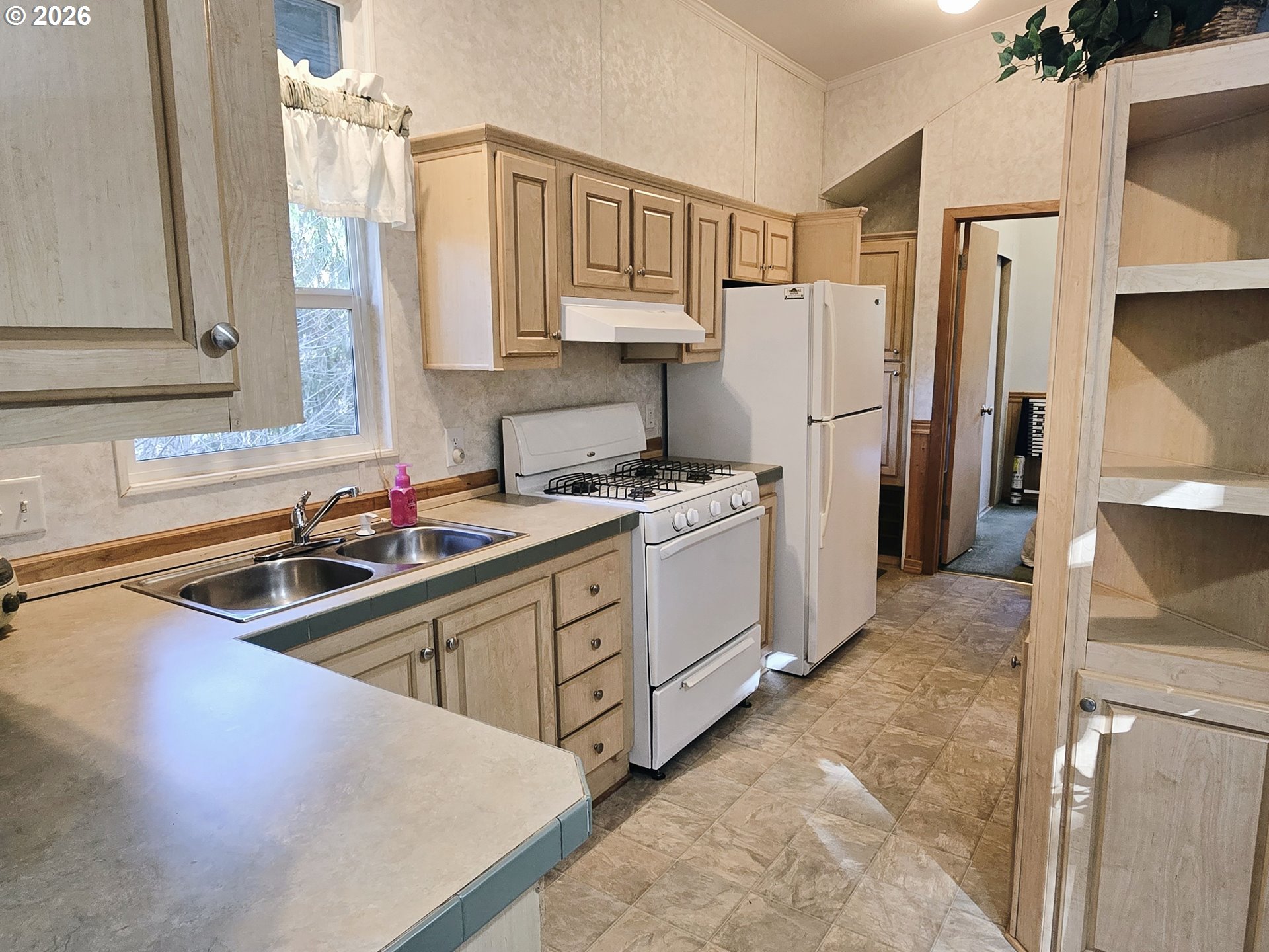 89491 Sutton Place Florence, OR 97439 - Photo 7 of 21 a kitchen with stainless steel appliances granite countertop a sink refrigerator and cabinets