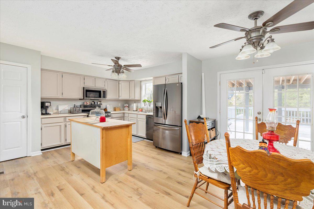 10346 Groves Farm Road Midland, VA 22728 - Photo 7 of 36 a kitchen with stainless steel appliances kitchen island granite countertop a refrigerator a stove a sink a dining table and chairs with wooden floor