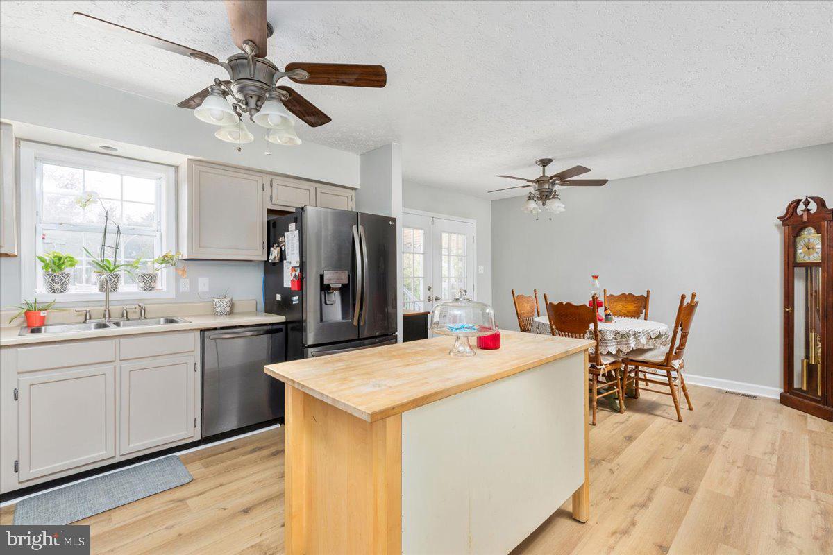 10346 Groves Farm Road Midland, VA 22728 - Photo 8 of 36 a open kitchen with stainless steel appliances kitchen island a table chairs and a refrigerator